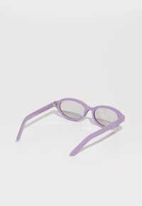 Gafas de sol moradas con lentes ovalados, un acabado brillante y brazos delgados. Presentan un sutil detalle en las bisagras, diseñadas para ofrecer comodidad ligera.