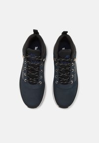 Navy blue athletic shoes with a suede and mesh upper, black laces, silver eyelets, padded collar, and white rubber sole.