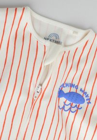 Body blanc pour bébé avec de fines rayures verticales orange, un graphique de poisson bleu, des vagues, et le texte « CATCHING WAVES » près de la fermeture éclair avant.