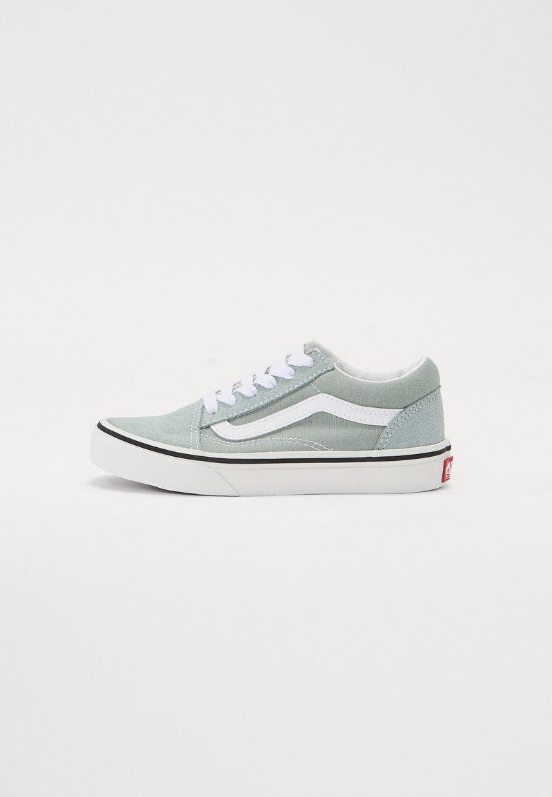 Sneakers in tela grigia chiara con accenti bianchi, silhouette classica, suola nera a contrasto e lacci bianchi. Dettaglio logo laterale visibile.