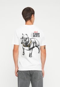 Balts kokvilnas T-krekls ar grafisku apdruku uz aizmugures, papildin�āts ar zelta ķēdes detaļu un uzrakstu "Huf 4 the Dawgs".