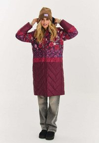 Fioletowy, pikowany długi płaszcz w kwiatowy wzór, z zamkiem z przodu, kontrastowym dolnym panelem oraz przytulną brązową dzianą czapką beanie.