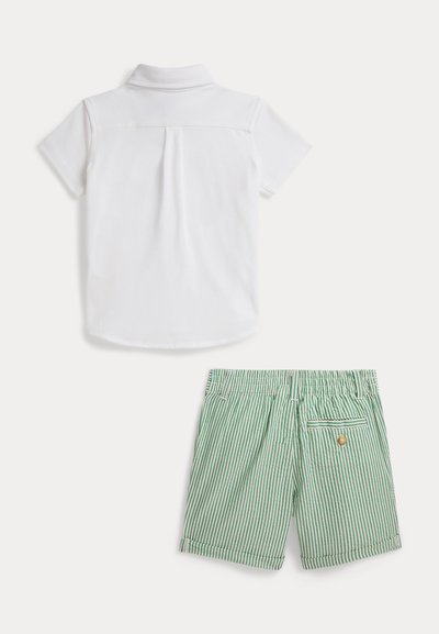 Λευκό πόλο πουκάμισο με κοντά μανίκια και πλάγια πτυχώση στην πλάτη· συνδυασμένο με πράσινα ριγέ σορτς με ελαστική μέση και πίσω τσέπη.