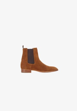 Bottines Chelsea en suede marron avec des panneaux élastiques latéraux sombres et une languette, dotées d'un bout rond et d'un petit talon empilé.