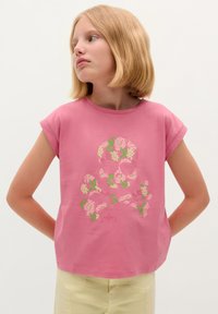 Roze katoenen T-shirt met korte mouwen, voorzien van een bloemig doodshoofd en gekruiste botten ontwerp in pasteltinten. Bovenaan staat de merknaam "Scalpers."