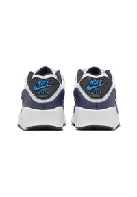 Nike Air tenisky s námořnickou modrou a bílou barevnou kombinací, z materiálů síťoviny a kůže, polstrovaným límcem a vyznačujícím se logem na patě.