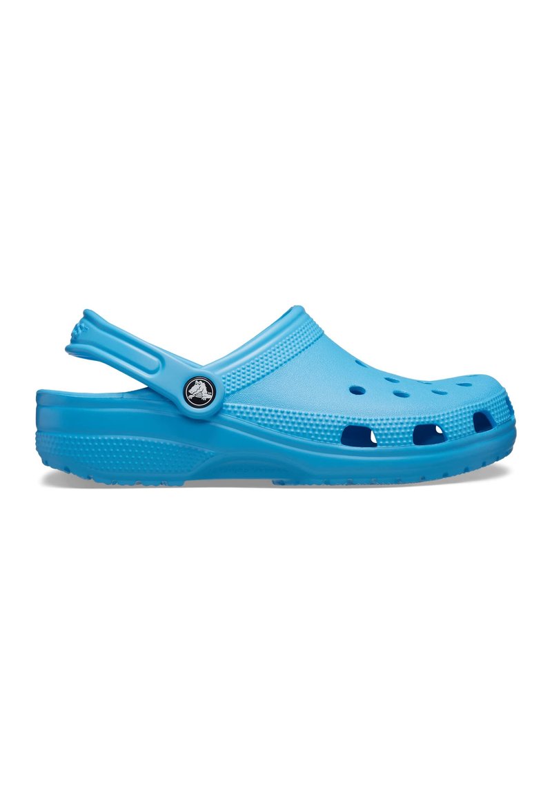 Zoccoli blu realizzati in materiale schiumoso flessibile, dotati di fori di ventilazione, cinturino posteriore e superficie texturizzata. Punta rotonda e design leggero.