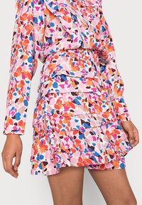 Robe florale avec des motifs roses, oranges et bleus, design à volants superposés et taille élastique ; fabriquée en tissu léger.