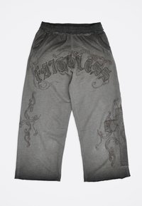 Γκρι παντελόνι χαλαρής εφαρμογής με μαύρη ελαστική μέση, διακοσμητικά σκούρα στροβιλιστά σχέδια και κείμενο "FATIGUES" στο μπροστινό πάνω μέρος των μηρών.