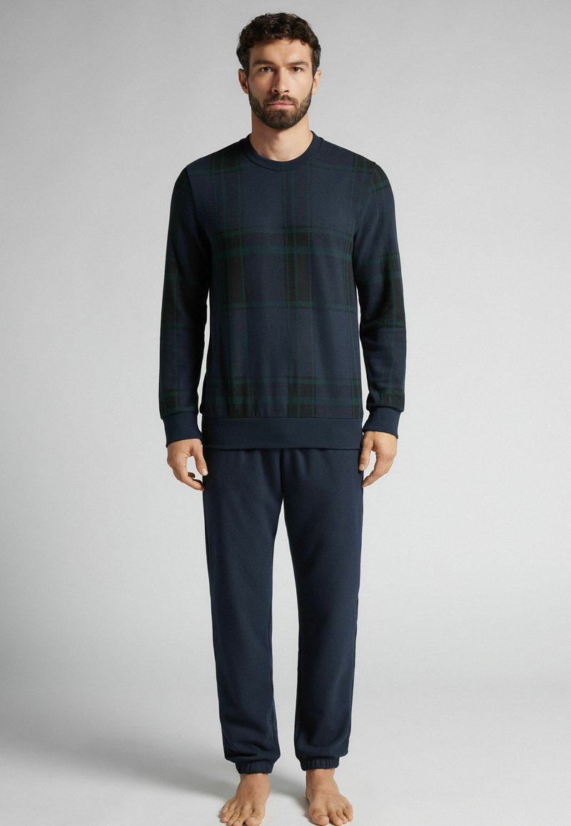 Námořnická kostkovaná mikina s dlouhým rukávem a žebrovanými manžetami, spárovaná s odpovídajícími námořnickými tepláky s elastickým pasem a manžetami.