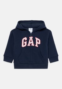 Felpa con cappuccio per bambino di colore blu navy, con zip frontale, tasca a marsupio e logo "GAP" in lettere bianche contornate di rosso sulla parte frontale.
