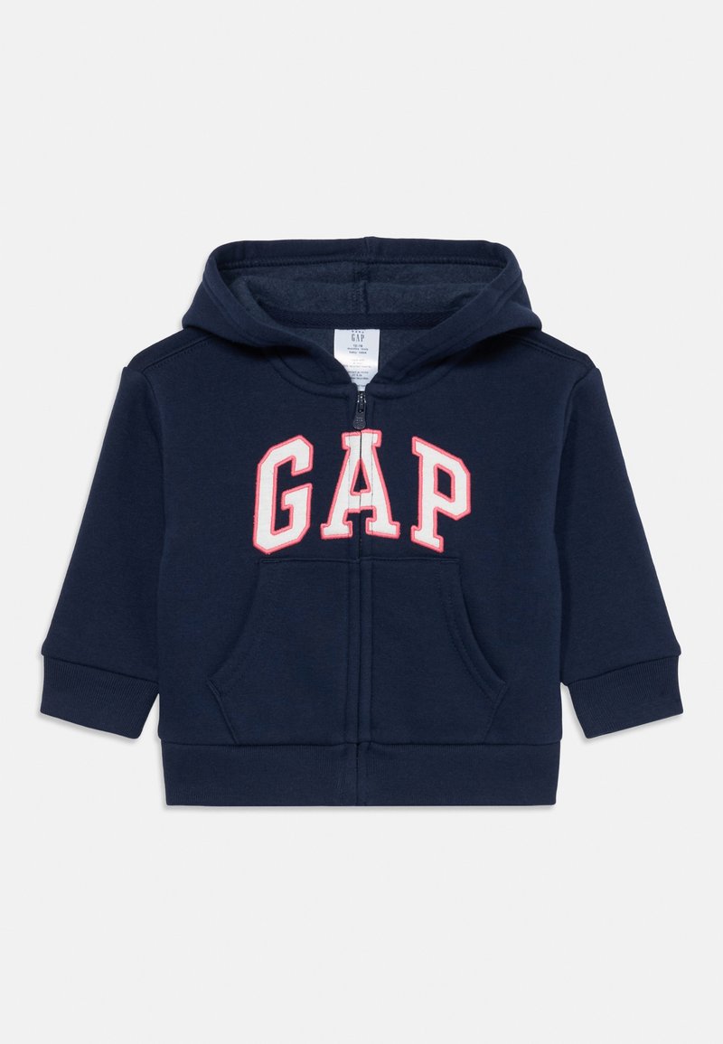 Felpa con cappuccio per bambino di colore blu navy, con zip frontale, tasca a marsupio e logo "GAP" in lettere bianche contornate di rosso sulla parte frontale.