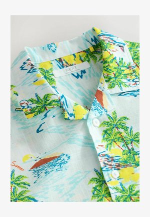 Camicia a maniche corte con colletto in tessuto azzurro chiaro, decorata con stampa tropicale che presenta palme, spiagge e onde; dotata di bottoni bianchi.