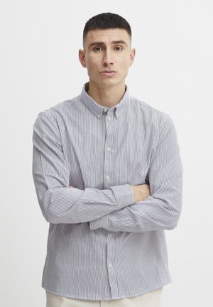 Striped button-up shirt in light blue and white cotton, featuring a collar and long sleeves, with a classic fit and subtle textures.