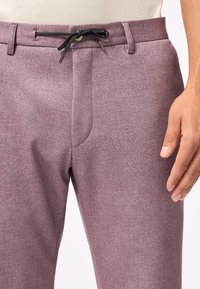 Schlank geschnittene Hose aus einem strukturierten, hellvioletten Stoff, mit einem Kordelzugverschluss und flachem Vorderteil sowie seitlichen Taschen.