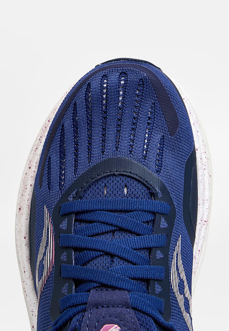 Zapatilla deportiva de la marina con parte superior de malla transpirable, acentos texturizados y suela blanca moteada. Presenta cordones planos y puntera reforzada.