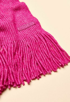 Ružový pletený šál s detailom strapcov. Má textúrované tkanie a značkovú nálepku. Materiál vyzerá mäkko a útulne.