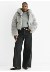 Gray faux fur jacket with a hood, ribbed gray sweater, wide-leg black jeans, and black flats. Textured fur pattern on the jacket.