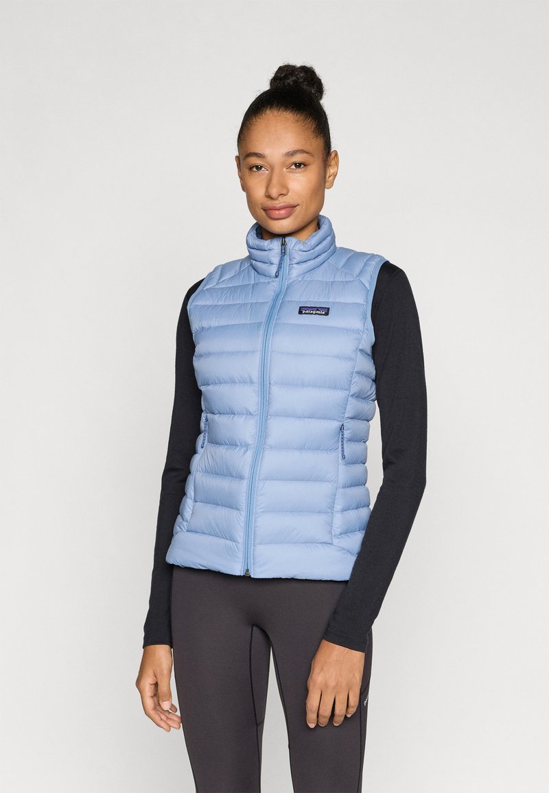 Ανοιχτό μπλε μπουφάν χωρίς μανίκια με ψηλό γιακά, κλείσιμο με φερμουάρ και δύο πλαϊνές τσέπες. Διαθέτει ραμμένα πάνελ για μόνωσ η και είναι ελαφρύ.