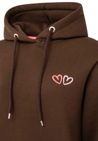 Brązowa bluza z kapturem i sznurkiem, z dwoma haftowanymi sercami w kolorach różowym i czerwonym. Miękka tkanina o gładkiej teksturze oraz metalowe akcenty na sznurku.