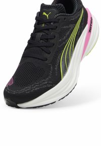 Must have spordijalatsid musta tekstuuriga pealmise osaga, millel on ere rohelised detailid, roosa kand ja valge vaheosa. PUMA logo keelel ja külgedel.