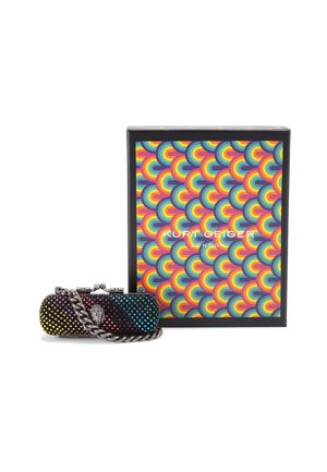 Kleine, mehrfarbige Clutch mit Nieten, Silberkette und dekorativem Verschluss, neben einer bunten, geometrisch gemusterten Box mit der Aufschrift Kurt Geiger London platziert.