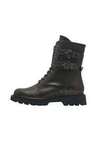 Botas de tobillo de cuero marrón oscuro con dos hebillas, detalles de tachuelas, puntera redonda y suela gruesa negra. Presentan cordones tradicionales.