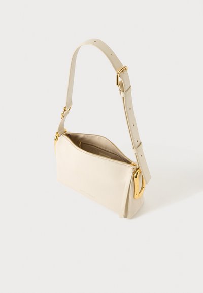 Sac à bandoulière en cuir couleur crème avec une sangle réglable, des détails de boucle dorée et un haut partiellement ouvert avec fermeture éclair laissant voir la doublure intérieure.
