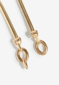 Øreringe i guldfarvet metal har et glat, snoet design med teksturerede, cirkulære led og en markant, ribbet detalje ved lukningen.