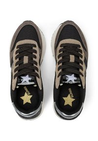 Un paio di sneaker in suede e tessuto nero e marrone con lacci neri e loghi a forma di stella dorata all'interno e sulla linguetta.