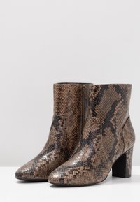 Brown faux leather ankle boots with a snakeskin pattern, pointed toe, side zipper, and a block heel. Smooth texture and glossy finish.