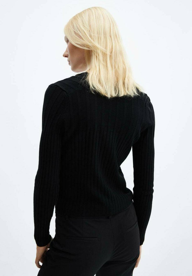 Maglione lungo a maniche lunghe nero a costine con un design aderente, scollatura tonda e tessuto strutturato. Vista dalla schiena, che mette in risalto la silhouette.