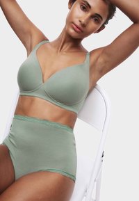 Lysegrøn bh med glat materiale og trekantede skåle, kombineret med matchende trusser med høj talje og blonderkant.