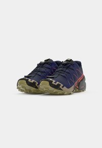 Trail running shoes in navy with red accents. Lightweight design, textured upper, rubber sole with aggressive tread for traction.