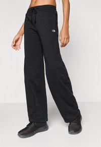 Μαύρο παντελόνι φόρμας με ελαστική μέση και κορδόνι. Κατασκευασμένο από μαλακό ύφασμα με πλαϊνές τσέπες και μικρό λογότυπο στο σημείο του μηρού.