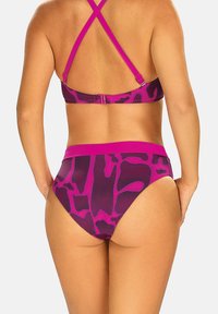 Fioletowy zestaw bikini z geometrycznym wzorem, krzyżującymi się ramiączkami oraz kontrastującą taśmą w pasie. Gładka tekstura.