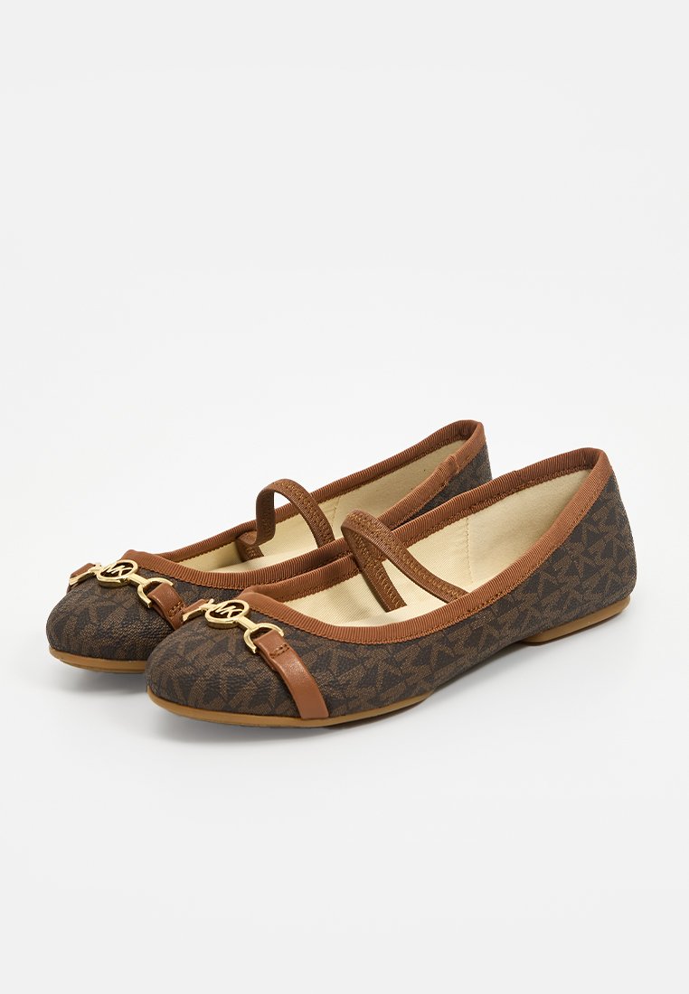 Scarpe piatte in tela marrone con un design a motivo, dettagli in pelle marrone e una catena dorata sulla punta. Fascetta attraversata sul piede.