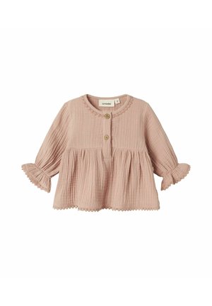 Blouse en coton texturé rose avec un col rond, deux boutons en bois et des manches ruffles ornées d'une dentelle le long de l'ourlet.