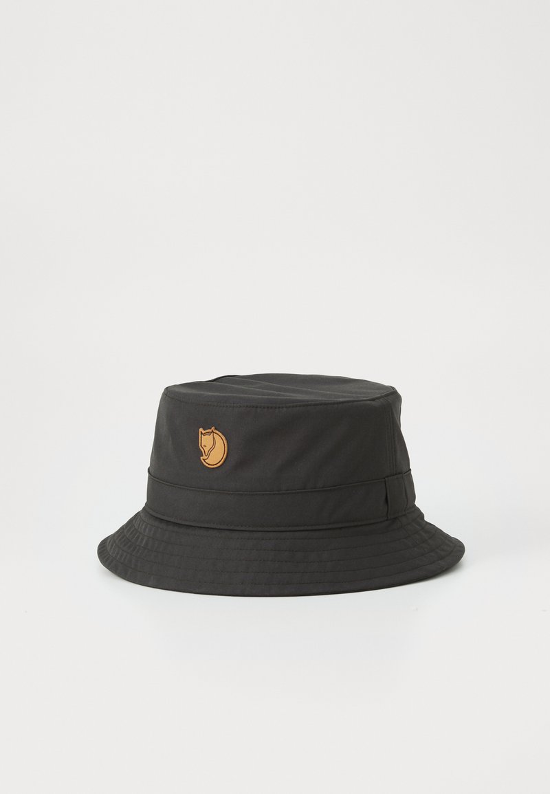 Chapeau seau noir en tissu durable avec un logo brodé beige, doté d'un large bord et d'un design structuré.