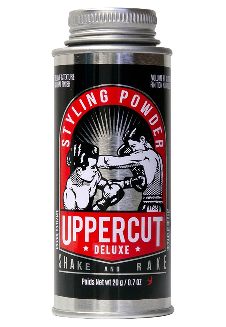 Metallbehållare med Uppercut Deluxe stylingpulver, med en svart etikett med röda accenter, illustrerade boxare och ett silvrigt skruvlock.