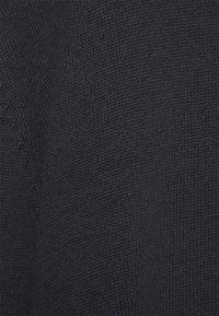 Tessuto a maglia blu navy che mostra una trama fitta con modelli di punto uniformi. Il materiale appare morbido e flessibile, adatto per l'uso nell'abbigliamento.