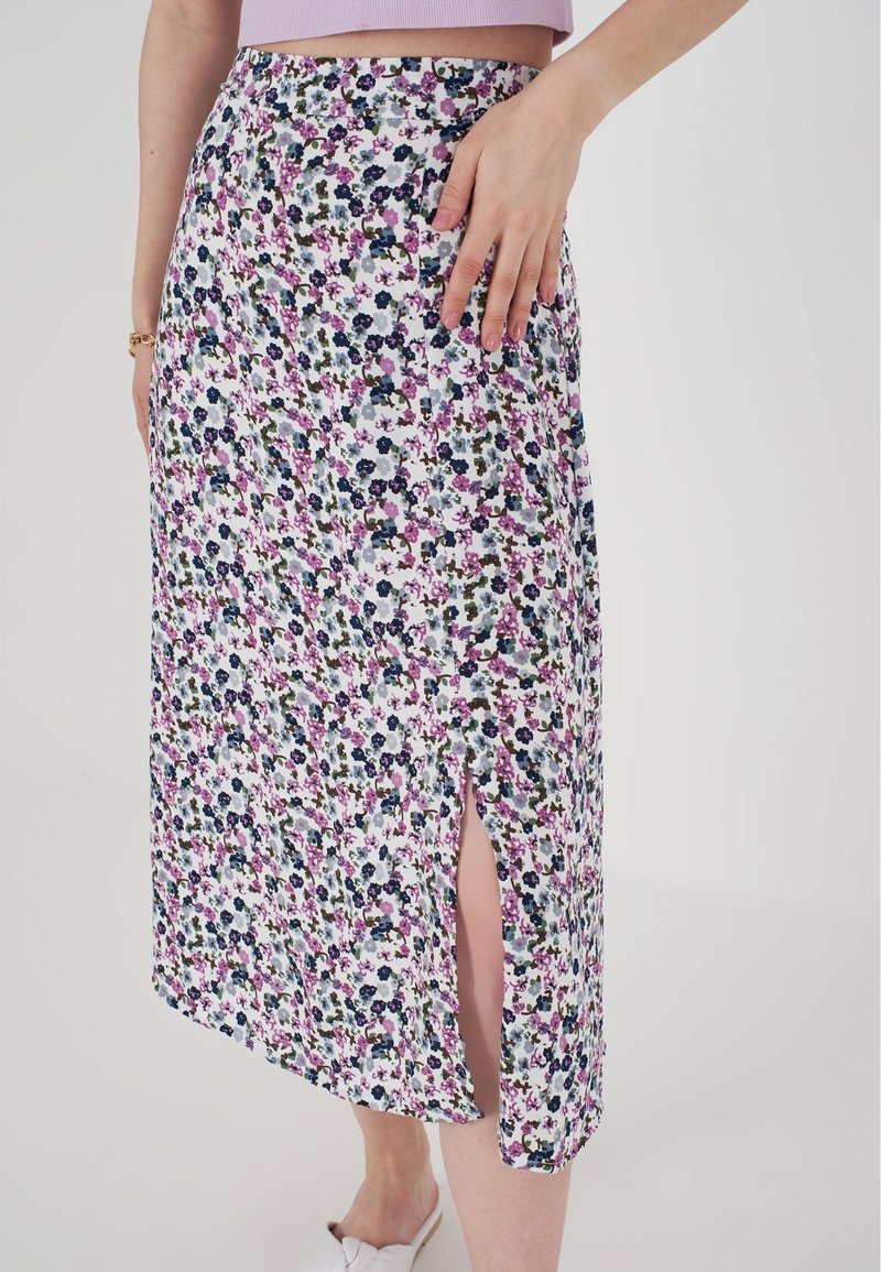 Gonna midi floreale con spacco laterale, caratterizzata da una base bianca con motivi rosa, blu e verdi. Tessuto leggero e vestibilità dritta.
