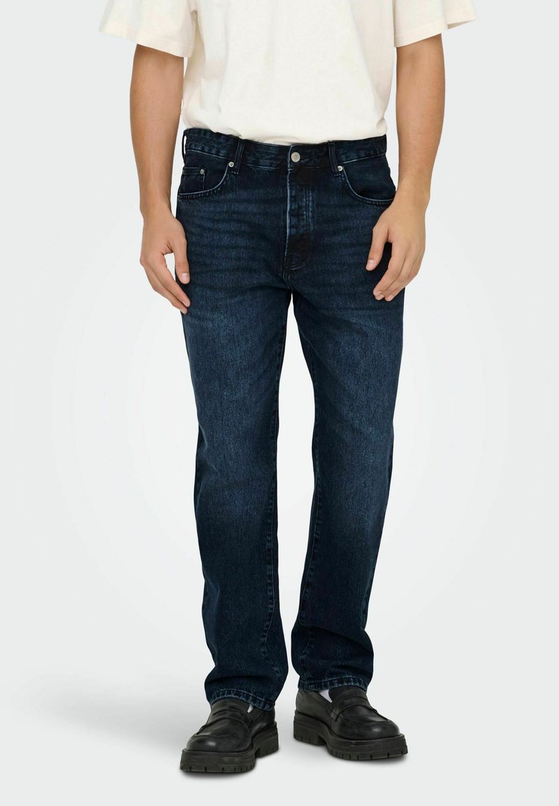 Jeans de mezclilla azul oscuro con corte recto, diseño de cinco bolsillos y una cinturilla resistente con costuras visibles y detalles de metal.
