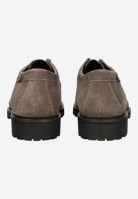 Chaussures en daim marron à profil bas, bout rond et semelle en caoutchouc grise texturée. Elles présentent des détails de couture et des languettes à l'arrière.