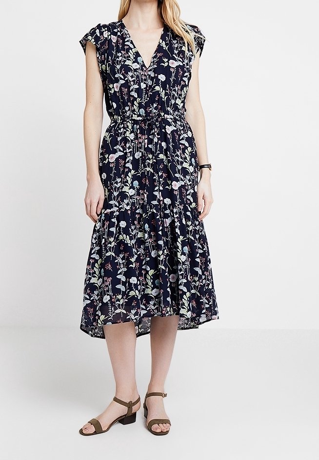 Blommig midiklänning med marinblå bakgrund, V-ringning, korta ärmar och rynkad midja. Lätt tyg med flerfärgade blommönster.