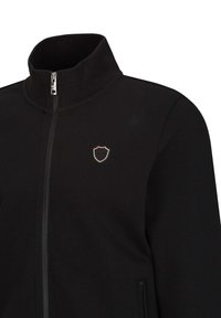 Zwarte zip-up jack met hoge kraag, voorzien van een klein geborduurd schildlogo op de borst en een textuurdesign.