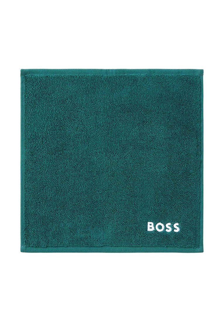 Türkisfarbener Badteppich aus weichem Frottee mit strukturiertem Oberflächenmaterial. Weißes "BOSS"-Logo bestickt in der unteren rechten Ecke. Rechteckige Form.
