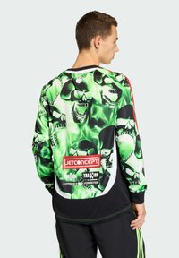 Langermige shirt met een levendig groen en zwart schedelpatter, voorzien van een logo en tekst op de achterkant, gemaakt van een soepele stof.