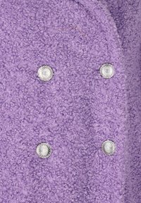 Tessuto di lavanda con texture e finitura shaggy, presenta quattro accenti con bottoni in argento. I bottoni hanno un design decorativo simile a un fiore.