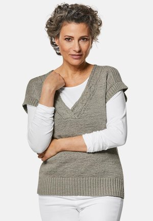 Grauer gestrickter Weste mit V-Ausschnitt und kurzen Ärmeln, die über einem weißen Langarmshirt getragen wird. Der Stoff hat eine strukturierte Oberfläche und einen gerippten Saum.